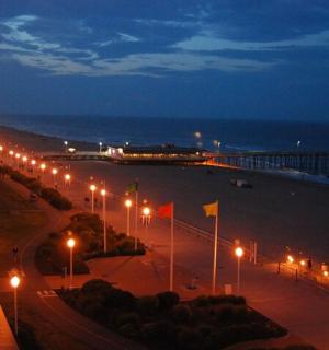 a view of a beach at night with street lights