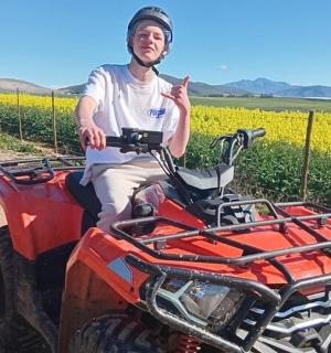 a man sitting on a atv in front of a field