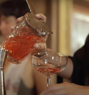 člověk nalévá víno do sklenice na víno