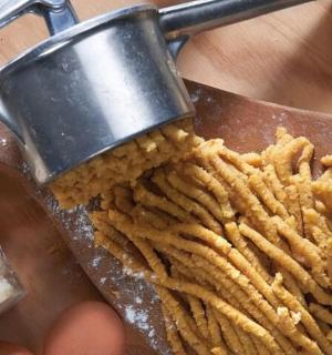 osoba držící příbor s hromadou hranolků