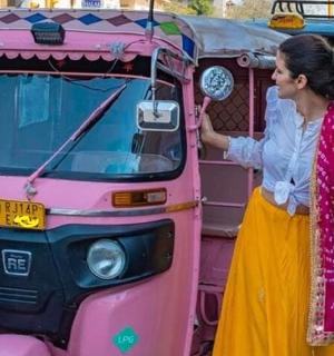 žena stojící před růžovým autobusem