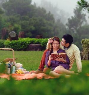 一男一女坐在草地上的毯子上