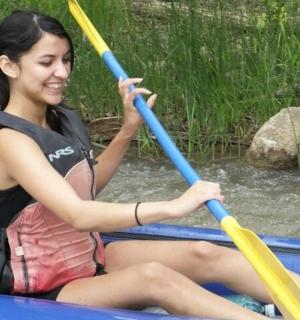 一位女士坐在一艘有两支桨的船上