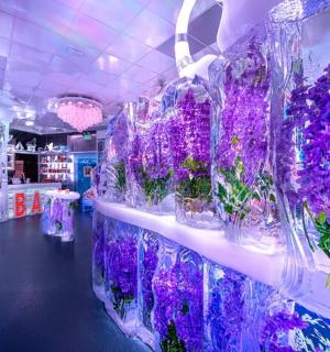 a flower shop with purple flowers in glass vases