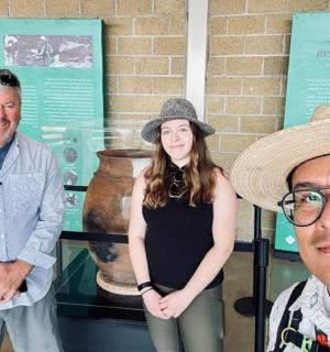 两名男子和一名女子站在博物馆前