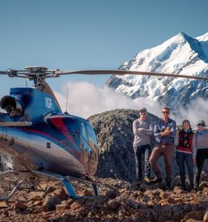 a group of people standing next to a helicopter