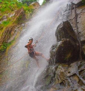 a person on a rope in front of a waterfall