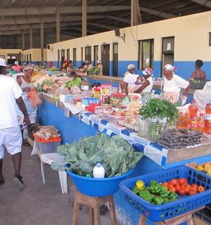 a group of people standing at a market with produce