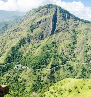 a woman standing on a ledge overlooking a mountain