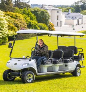 muž sedící v golfovém vozíku na trávě