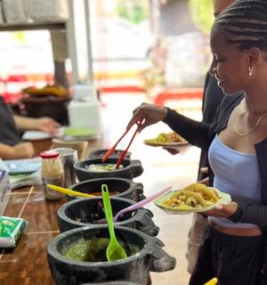 a woman holding a plate of food on a table