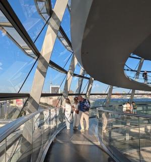 a group of people walking on a glass revolving building