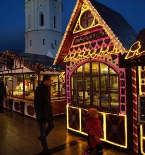 muž a dítě stojící před vánočním trhem