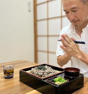 muž sedící u stolu s talířem jídla