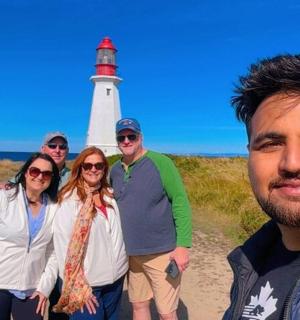 a group of people standing in front of a lighthouse