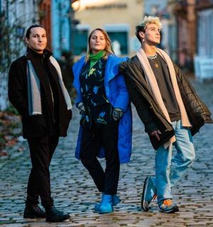 skupina tří lidí jdoucích po ulici