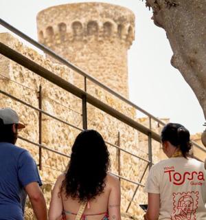 skupina lidí procházejících se kolem hradu