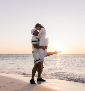 a man and a woman standing on the beach