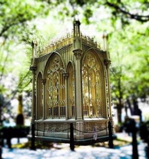 a gold cage in the middle of a park