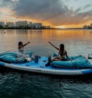 two women are sitting on anlatable raft on the water