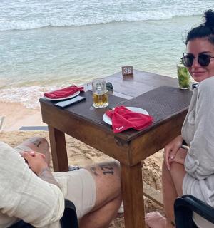 a man and a woman sitting at a table at the beach