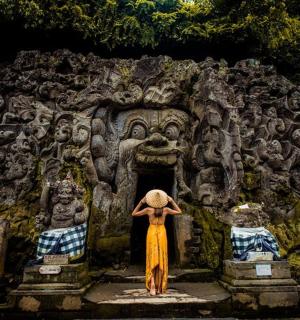 a woman is standing in front of a temple