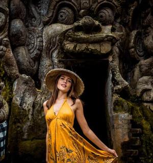 a woman in a yellow dress standing in front of a building