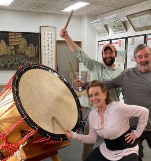 dva muži a žena stojící vedle bubnu