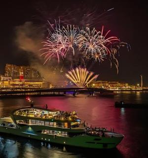 a boat in the water with fireworks in the background
