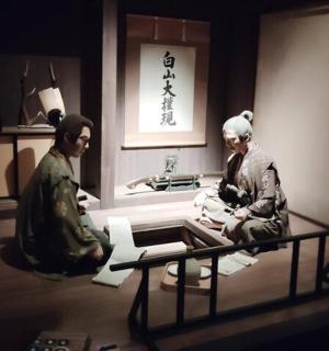 two people sitting in a room with a window