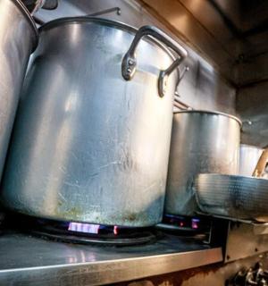 two large pots on a stove in a kitchen