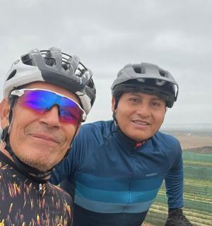 two men wearing helmets standing on top of a hill