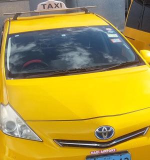 一辆黄色轿车停在一辆黄色巴士旁边