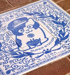 a blue and white tile with a picture of a woman