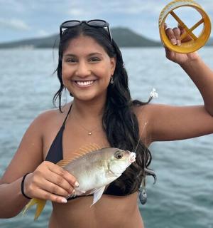 船上抱着鱼的女人