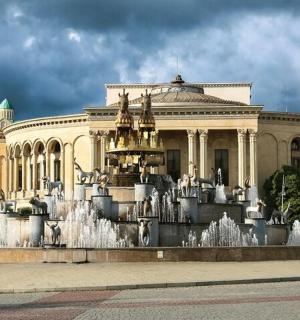 a large building with a fountain in front of it