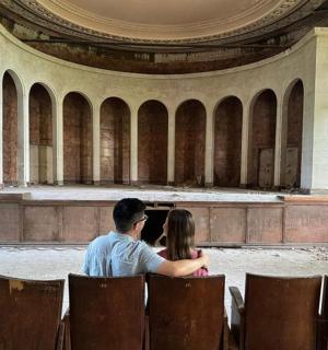 a man and a woman sitting in an empty building