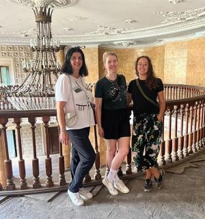 three women standing on a staircase in a building