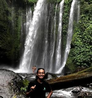 一名男子站在瀑布前