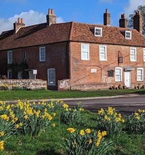 a large brick house with yellow flowers in front of it