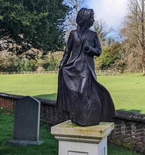 a statue of a woman sitting on a wall