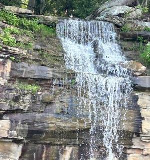 a waterfall on a rock wall in a park