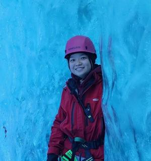 一个小男孩站在冰墙旁边