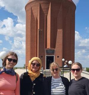 a group of women standing in front of a clock tower