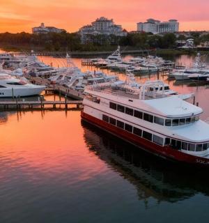 Skupina lodí zakotvených v přístavu při západu slunce