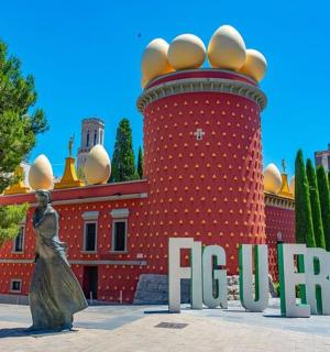 一座红色的大楼,前面有一座雕像