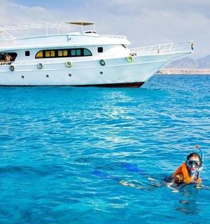 osoba ve vodě před lodí