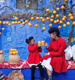 muž a malá holčička sedící vedle modré zdi