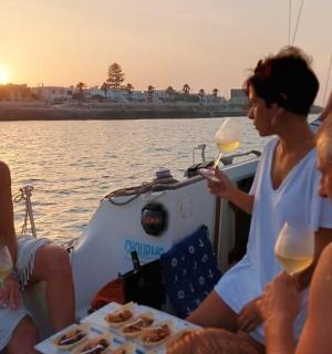 eine Gruppe von Menschen sitzt mit Weingläsern auf einem Boot