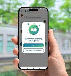 一个人拿着 iPhone，上面显示着 Facebook 应用程序